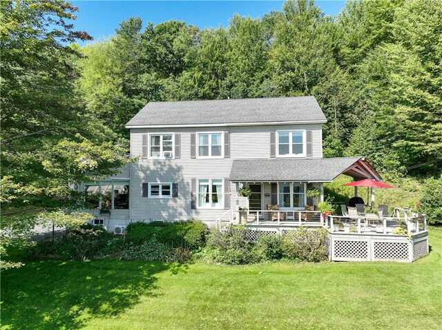 view of front of home featuring a front yard and a wooden deck