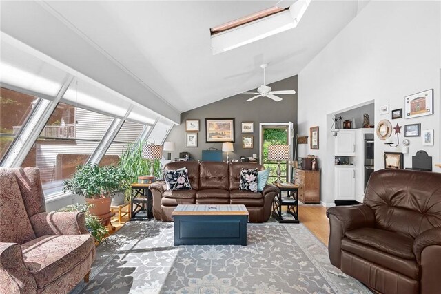 living room with hardwood / wood-style floors, high vaulted ceiling, a healthy amount of sunlight, and ceiling fan