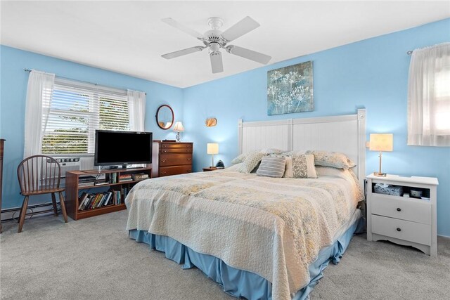 carpeted bedroom with ceiling fan, cooling unit, and a baseboard heating unit