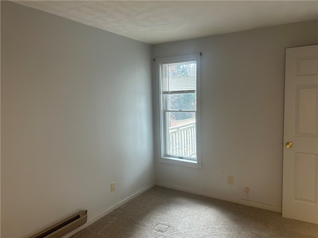 carpeted spare room featuring baseboard heating