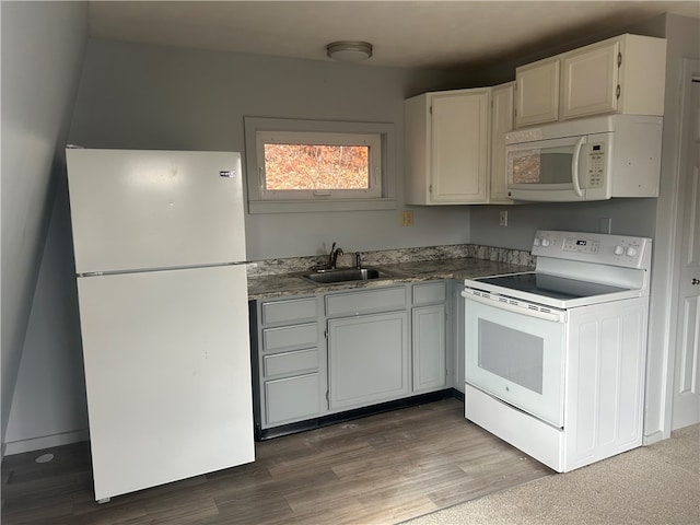 kitchen with white appliances, white cabinets, sink, and hardwood / wood-style floors