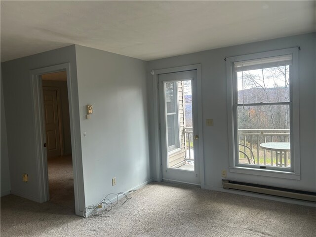 doorway with a baseboard heating unit and light colored carpet