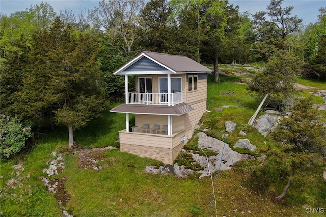 view of front of house with a front lawn and a balcony