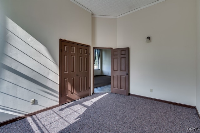 unfurnished room with ornamental molding and carpet floors