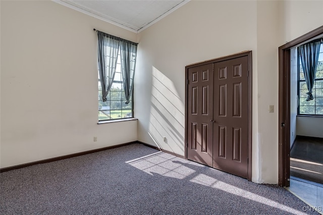 unfurnished bedroom with a closet, carpet flooring, and crown molding