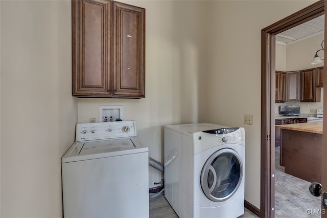 laundry area featuring washing machine and clothes dryer and cabinets