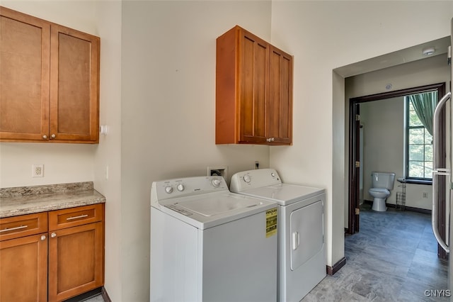 clothes washing area with cabinets and independent washer and dryer