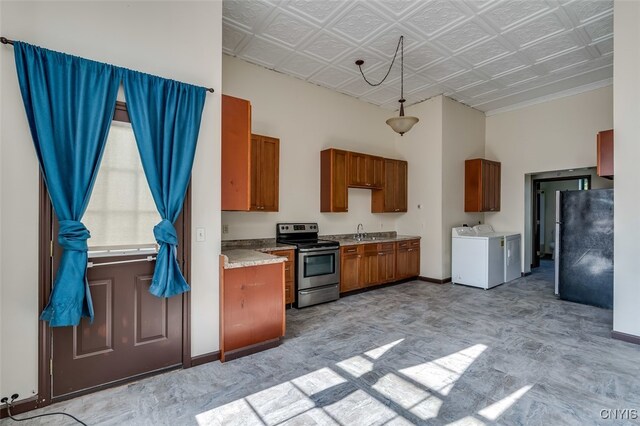 kitchen featuring separate washer and dryer, ornamental molding, black refrigerator, stainless steel electric stove, and sink