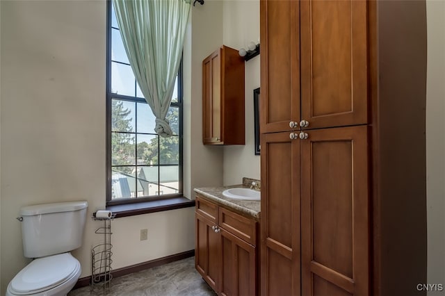 bathroom with vanity, toilet, and a wealth of natural light