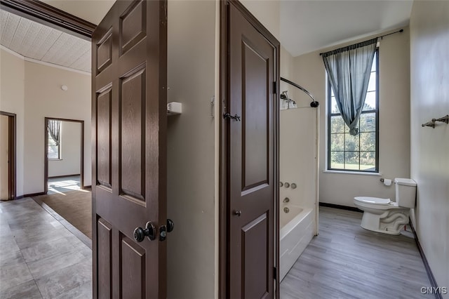 bathroom featuring ornamental molding, toilet, hardwood / wood-style flooring, and shower / bathtub combination