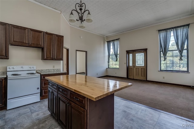 kitchen featuring a chandelier, white range with electric cooktop, butcher block countertops, and a healthy amount of sunlight