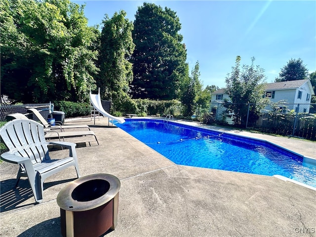 view of swimming pool with a water slide and a patio