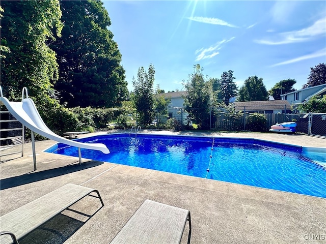 view of pool featuring a water slide and a patio area