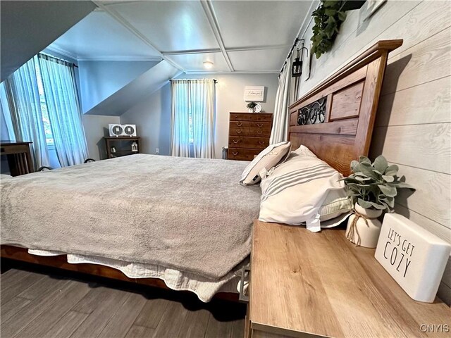 bedroom with wood-type flooring and wooden walls