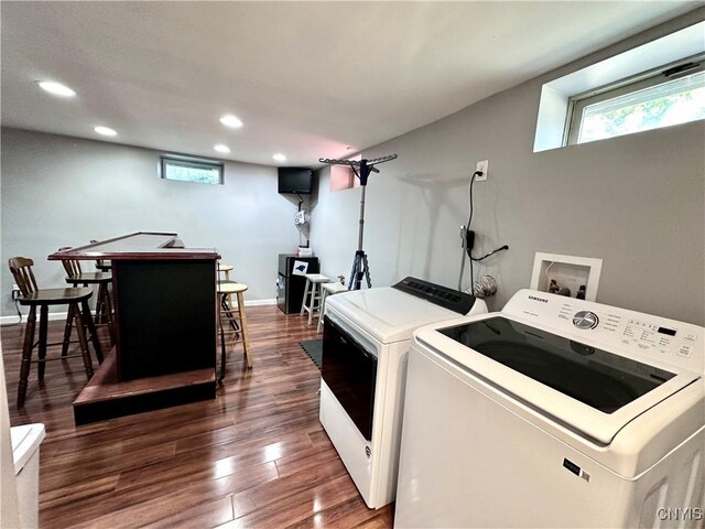 clothes washing area with dark hardwood / wood-style flooring and independent washer and dryer