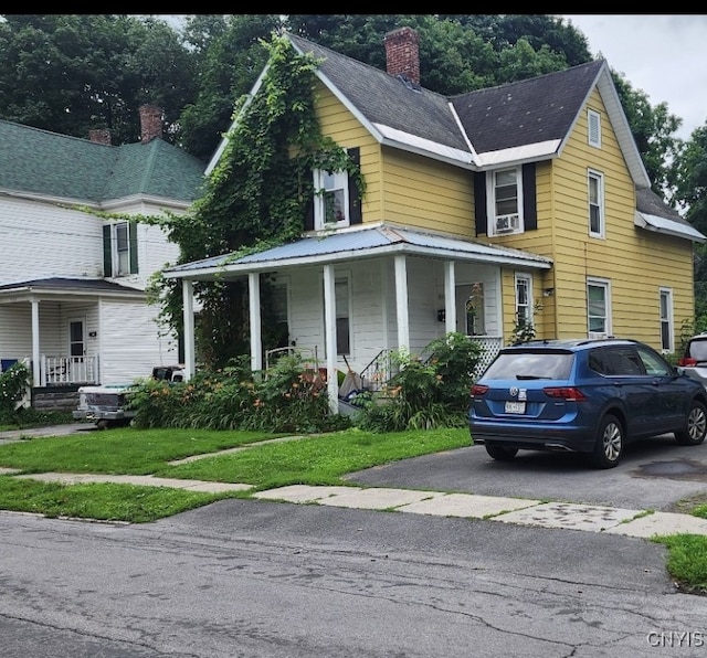 view of front of house featuring covered porch and a front yard