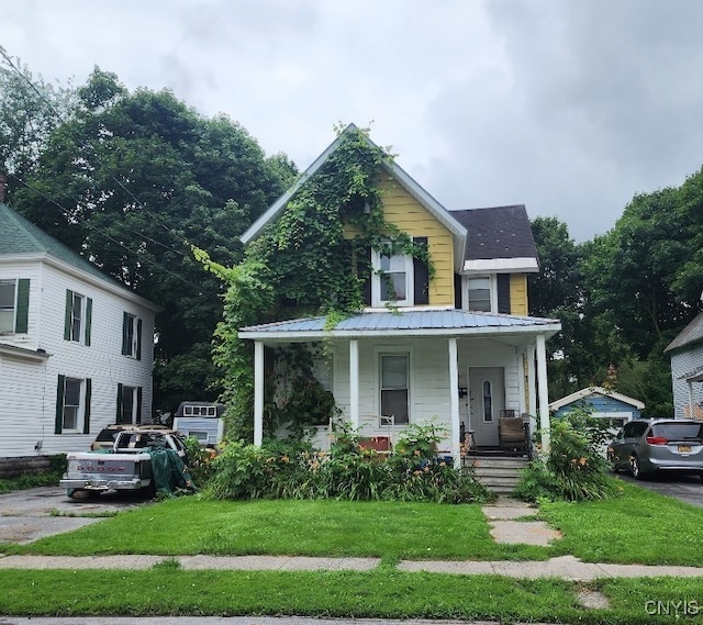 view of front of house with a front yard and covered porch