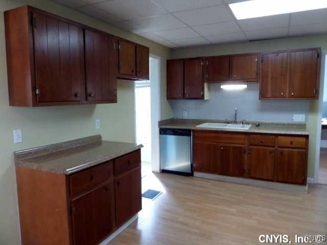 kitchen featuring a paneled ceiling, dishwasher, light hardwood / wood-style floors, and sink