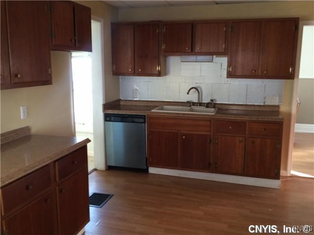 kitchen featuring wood-type flooring, dishwasher, and sink