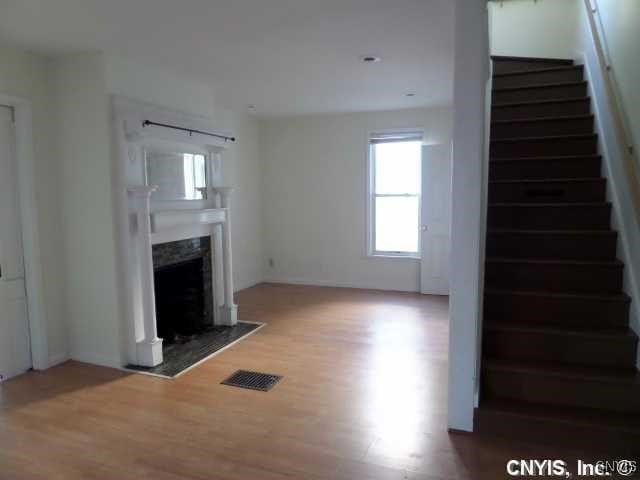 unfurnished living room with a premium fireplace and wood-type flooring