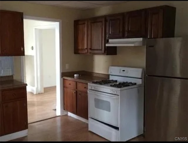 kitchen featuring stainless steel refrigerator and white range with gas cooktop