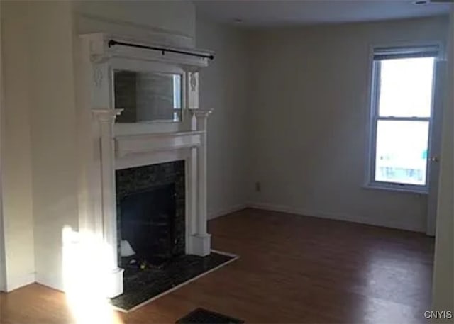 unfurnished living room featuring a premium fireplace and wood-type flooring