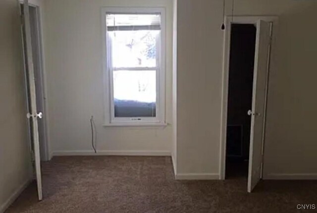 unfurnished bedroom with dark colored carpet