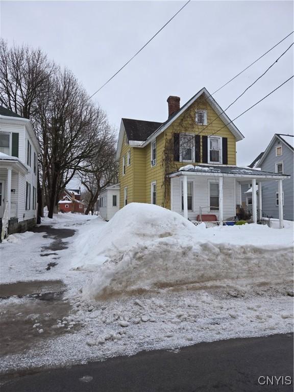 snow covered property featuring a chimney