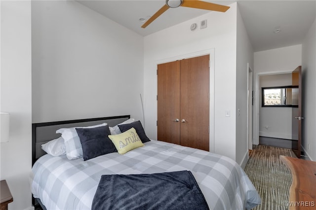 carpeted bedroom featuring ceiling fan and a closet