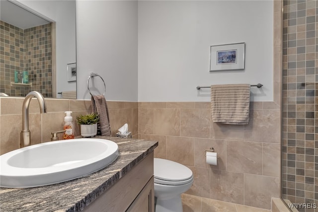 bathroom featuring vanity, tasteful backsplash, tile walls, toilet, and a shower