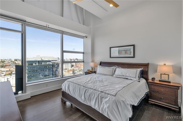 bedroom featuring a towering ceiling and dark wood-type flooring