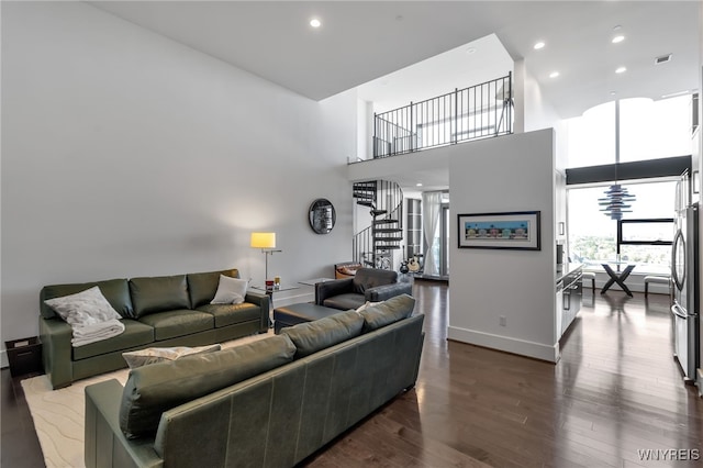 living room featuring a high ceiling and dark hardwood / wood-style flooring