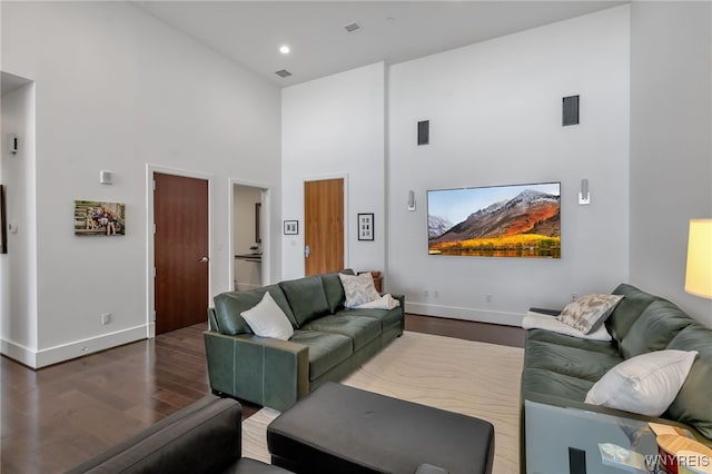 living room with a high ceiling and wood-type flooring