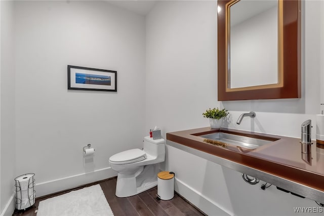 bathroom featuring toilet, sink, and hardwood / wood-style floors