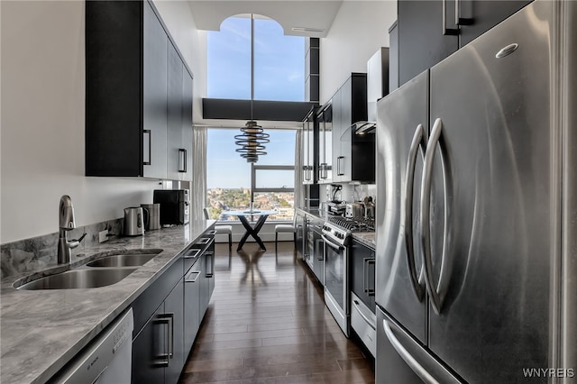 kitchen featuring light stone countertops, stainless steel appliances, dark hardwood / wood-style flooring, and sink