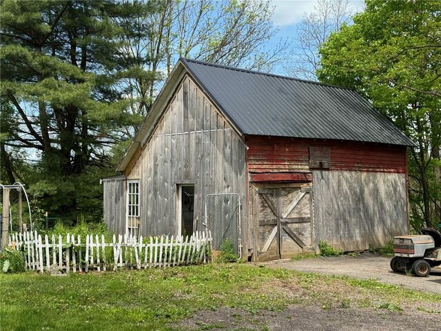 view of barn featuring fence