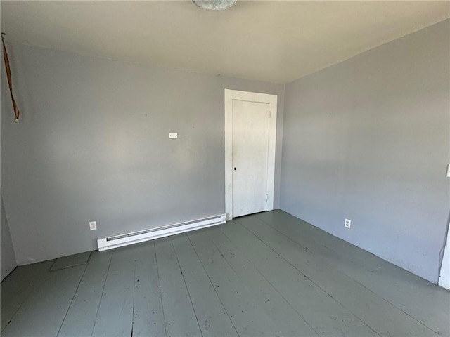 spare room featuring baseboard heating and hardwood / wood-style floors