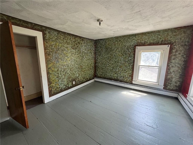 unfurnished bedroom with a textured ceiling, dark wood finished floors, and baseboards