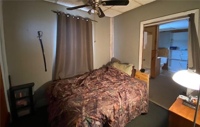 carpeted bedroom featuring a ceiling fan and a drop ceiling