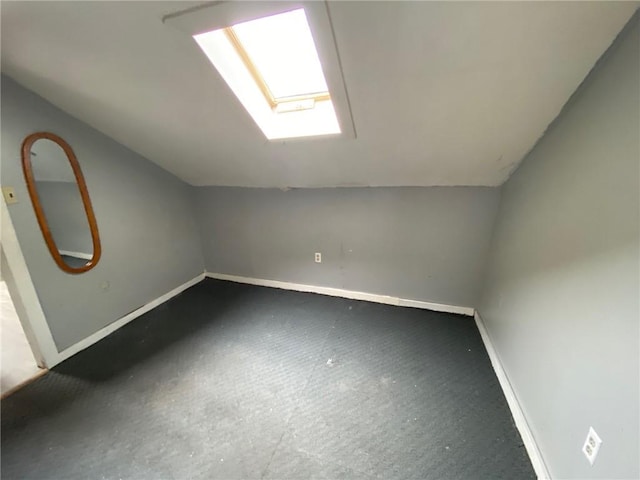 bonus room with carpet flooring, baseboards, and vaulted ceiling with skylight