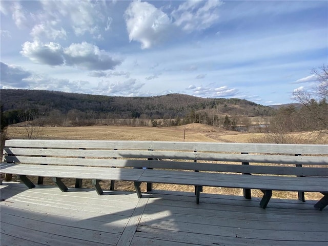 deck with a view of trees, a rural view, and a mountain view