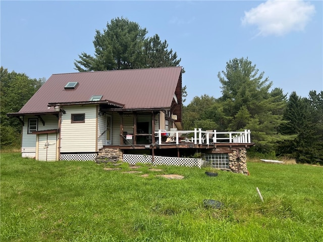 rear view of property with a yard and a deck