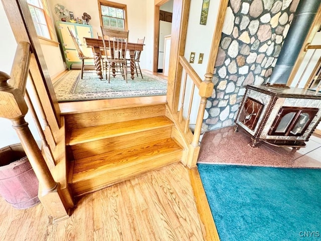 stairway featuring a wood stove and hardwood / wood-style flooring