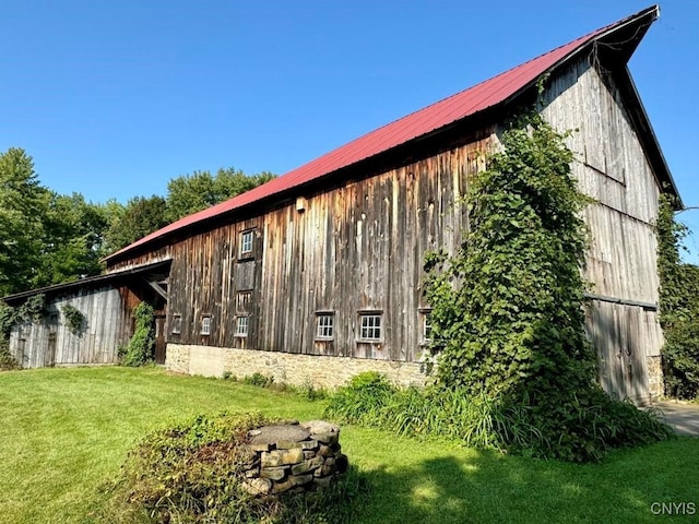 view of side of home with a lawn and an outbuilding