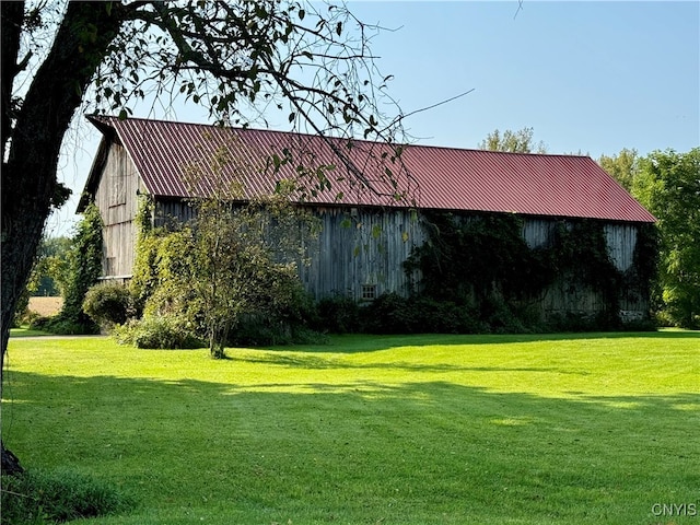 view of side of property with a lawn and an outdoor structure