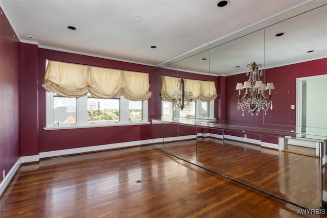 unfurnished dining area featuring a notable chandelier, ornamental molding, and hardwood / wood-style flooring