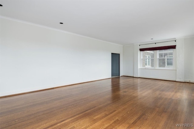 spare room with crown molding and wood-type flooring