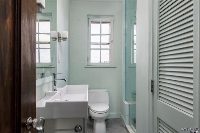 bathroom with toilet, an enclosed shower, sink, and tile patterned flooring