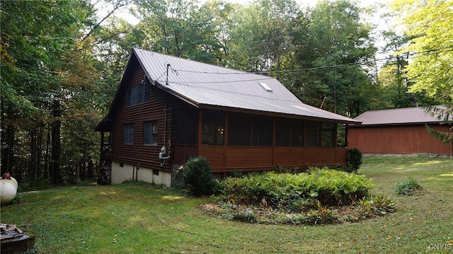 view of property exterior featuring a sunroom and a lawn