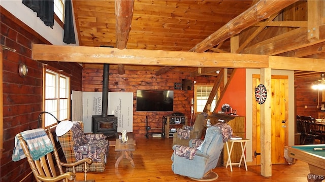 living room with pool table, lofted ceiling with beams, hardwood / wood-style floors, and a wood stove